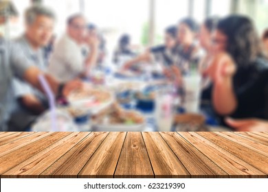 Wooden Board Empty Table In Front Of Blurred Background. Perspective People Sitting Together On Table For Lunch In Outdoor Restaurant Can Be Used For Display Or Montage Your Products