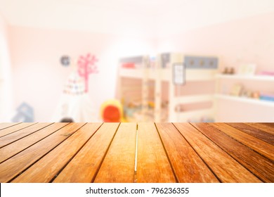 Wooden Board Empty Table In Front Of Blurred Background.Perspective Light Wood Over Blur In Kid Or Baby Room Interior- Can Be Used For Display Or Montage Your Products. Mock Up For Display Of Product.