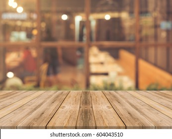 Wooden Board Empty Table Top On Of Blurred Background. Perspective Brown Wood Table Over Blur In Coffee Shop Background - Can Be Used Mock Up For Montage Products Display Or Design Key Visual Layout.