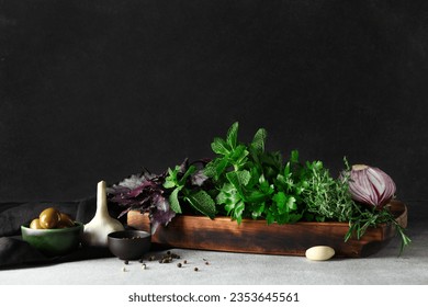 Wooden board with fresh herbs and spices on table against dark background - Powered by Shutterstock