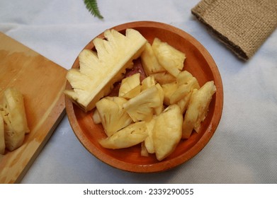 Wooden board with fresh sliced pineapple. top view and selective focus. - Powered by Shutterstock