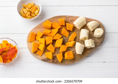 Wooden Board With Pumpkin And Banana Pulp Cut Into Pieces, Pumpkin Seeds And Pumpkin Peel. Cooking Delicious Pumpkin Banana Pancakes, Top View