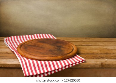 Wooden Board Stand On Tablecloth Over Grunge Background