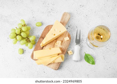 Wooden board with tasty Swiss cheese, glass of wine and grapes on light background - Powered by Shutterstock