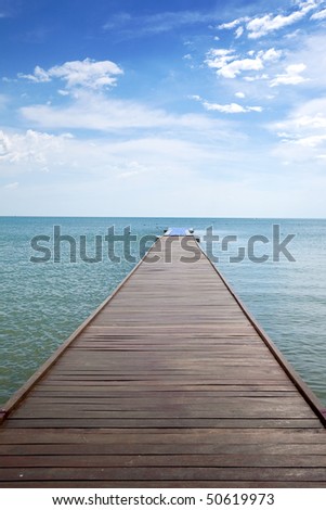 Wooden boardwalk above water out towards open ocean