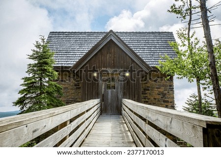 Wooden boardwalk leading to rustic wooden and brick cabin entrance in Snowshoe, West Virginia