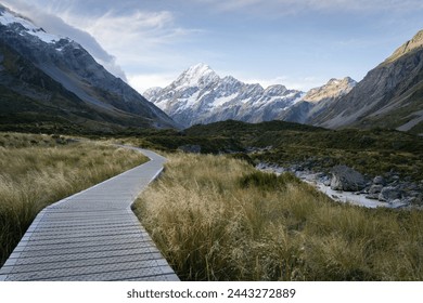 Wooden boardwalk leading through beautiful alpine valley with snowy mountain in backdrop,New Zealand - Powered by Shutterstock
