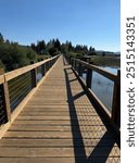 wooden boardwalk over a lake, forest and mountains in the background - Big Bear Lake, California