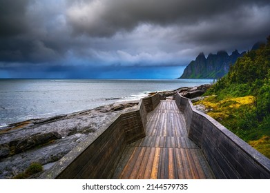 Wooden boardwalk at Tungeneset beach on Senja island in northern Norway. The Devils Jaw, or Tungeneset, is a spectacular range of jagged mountain peaks visible from the National Scenic Route on Senja.