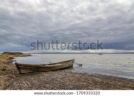 The wooden boat on the lake under the stormy sky. Braslaw, Belarus