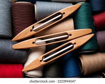 Wooden boat shuttles and bobbins with multicolored yarn, selected focus. Weaving shuttles waiting for work
