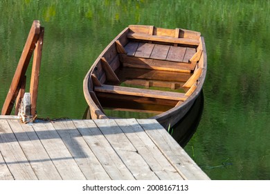 The Wooden Boat Is Sinking In The Water Of The Lake.