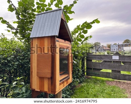 Wooden book box with signboard in Dutch language outdoors. Free library