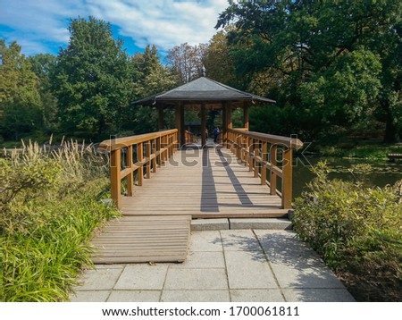 Wooden bower with wooden bridge in japanese garden