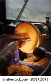 A wooden bowl being turned by a man on a woodturning lathe.A craftsman at work.Sawdust is flying.