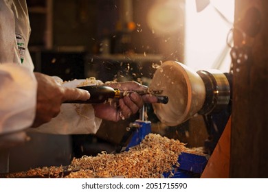 A wooden bowl being turned by a man on a woodturning lathe.A craftsman at work.Sawdust is flying. - Shutterstock ID 2051715590