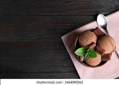 Wooden Bowl Of Chocolate Ice Cream Served On Dark Table, Flat Lay With Space For Text