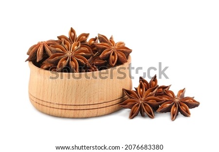Wooden bowl and dry anise stars on white background