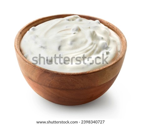 Wooden bowl of fresh sour cream dip sauce with herbs isolated on white background
