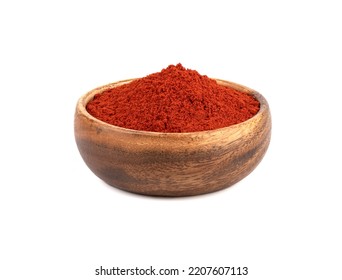 Wooden bowl full of smoked paprika on a white background.