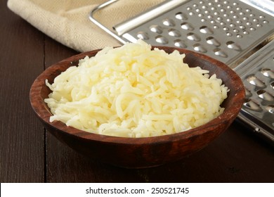 A Wooden Bowl Of Grated Swiss, Mozzarella, Or Monterrey Jack Cheese