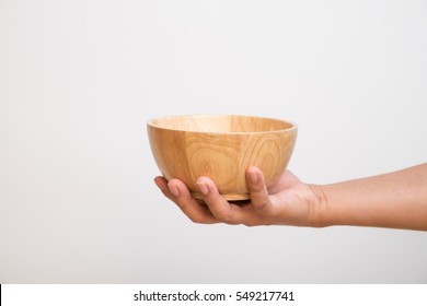 wooden bowl in hands on white background