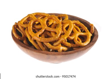 A Wooden Bowl Of Honey Mustard Pretzels On A White Background