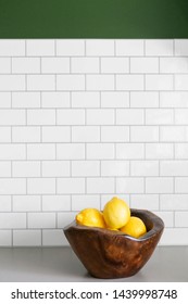 Wooden Bowl Of Lemons On Kitchen Counter, White Subway Tile Backsplash, Green Paint