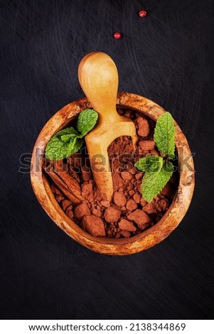 Ð¡ocoa  in wooden bowl and mint leaves on dark background. Candy set. 