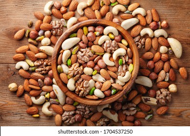 Wooden Bowl With Mixed Nuts On Rustic Table Top View. Healthy Food And Snack. 