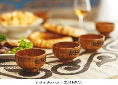 Wooden bowl with an ornament in the national Kazakh style. Central Asian ethnic dishes on the festive table Nauryz.