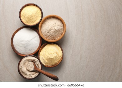 Wooden bowls with different types of flour on table - Shutterstock ID 669566476