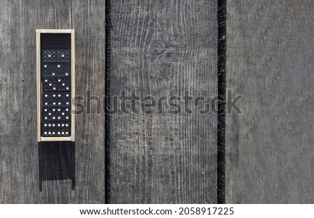 Wooden box with domino game pieces on wood desk. Banner with copy space.