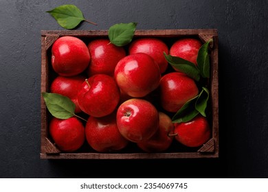 Wooden box with fresh red apples on stone table. Flat lay