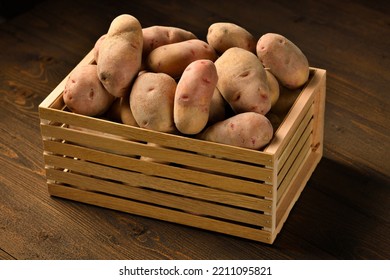 Wooden Box Full Of Potatoes On Dark Wooden Background