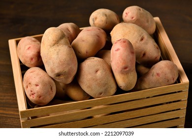 Wooden Box Full Of Potatoes On Dark Wooden Background