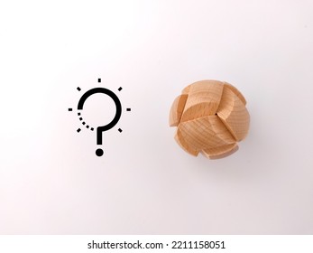 A Wooden Brain Teaser Puzzle With Solution And Question Icons On A White Background- Solution Concept