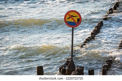 Wooden Breakwaters. Sign Forbidding Jumping From Breakwaters Into The Sea. Beach Hazard Warning Sign.