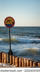 Wooden Breakwaters. Sign Forbidding Jumping From Breakwaters Into The Sea. Beach Hazard Warning Sign.