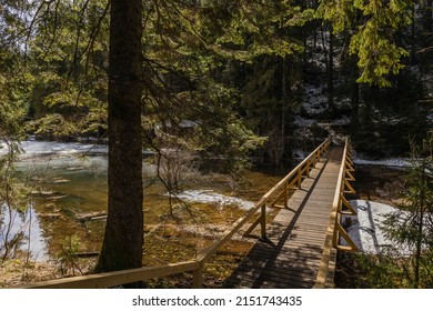 Wooden Bridge Above Lake With Ice In Forest