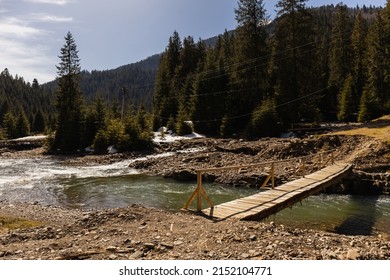 Wooden Bridge Above River In Mountains
