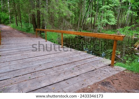 A wooden bridge built from planks across the stream