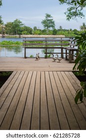 A wooden bridge expand along the canal and a wooden chair. - Shutterstock ID 621285728
