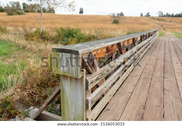Wooden bridge in a field in\
fall