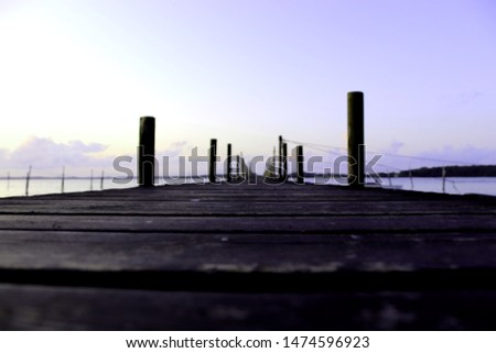 Wooden bridge into water at sunset in Denmark