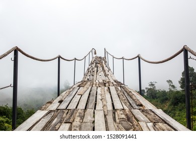 A wooden bridge over the jungle that breaks off at the end, Fog weather