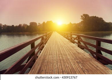 Wooden Bridge Over Lake In Early Misty Morning