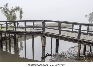 Wooden bridge over misty lagoon in the early morning. Ria de Aveiro, Portugal. - Powered by Shutterstock