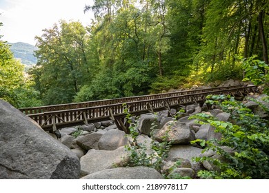 A Wooden Bridge Over Rocks In The Forest In Germany