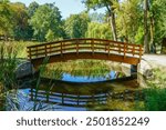 A wooden bridge over a small stream in the park in spring.
